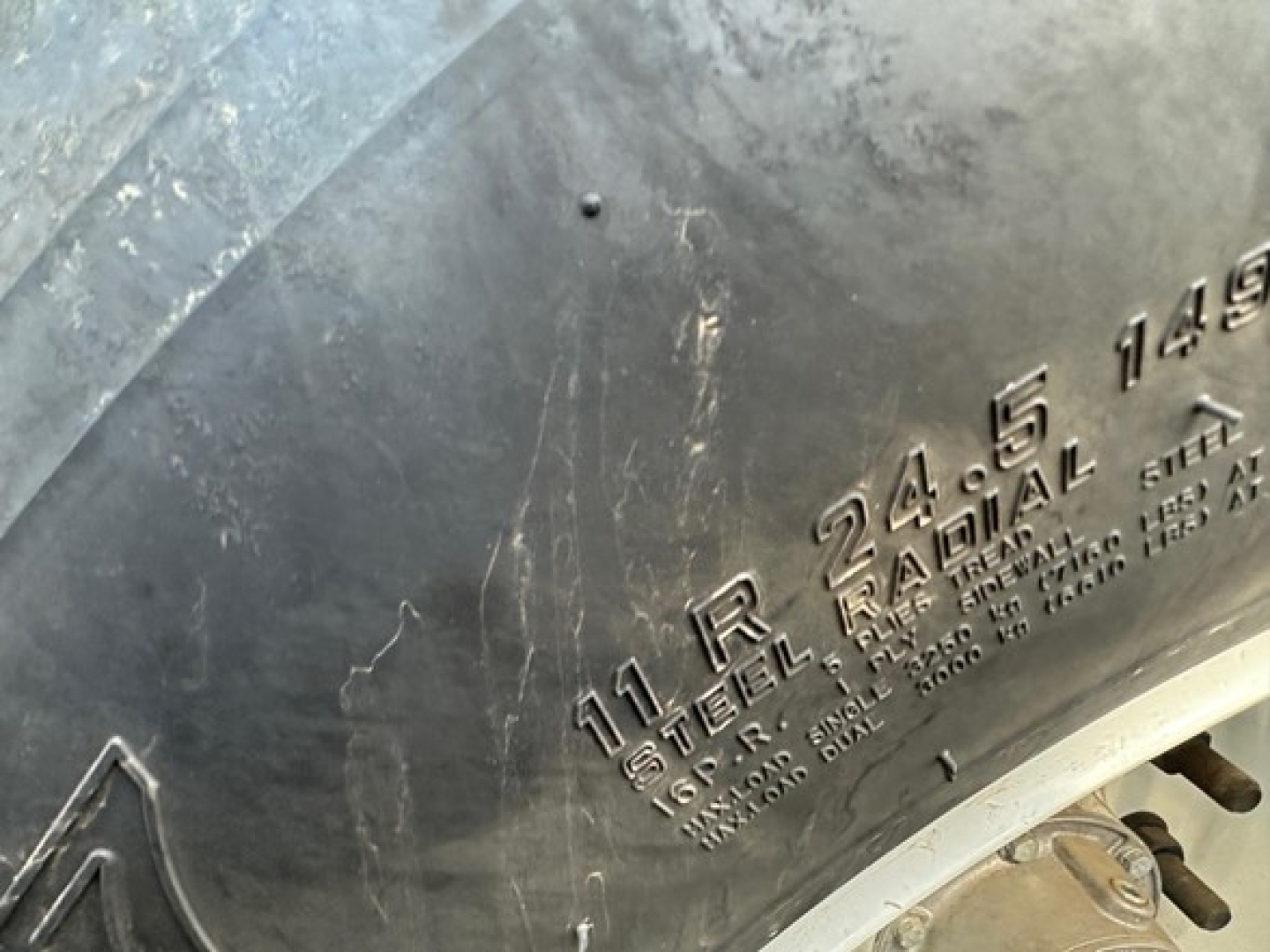 Trailer side showing stamped markings: '11 R 24.5 16 PR STEEL RAIL 1490' and other specs on steel surface; part of CPS Air Ride Bottom Dump trailer.