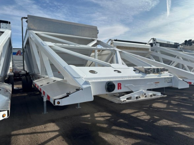 Bottom dump trailer frame showing white steel truss structure with R-logo plate and rear connection area.