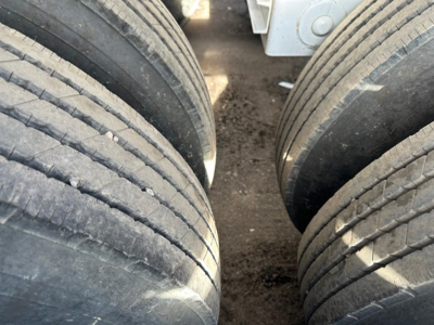Trailer chassis showing multiple heavy-duty tires of a CPS Air Ride Bottom Dump, tread visible on front left tire.