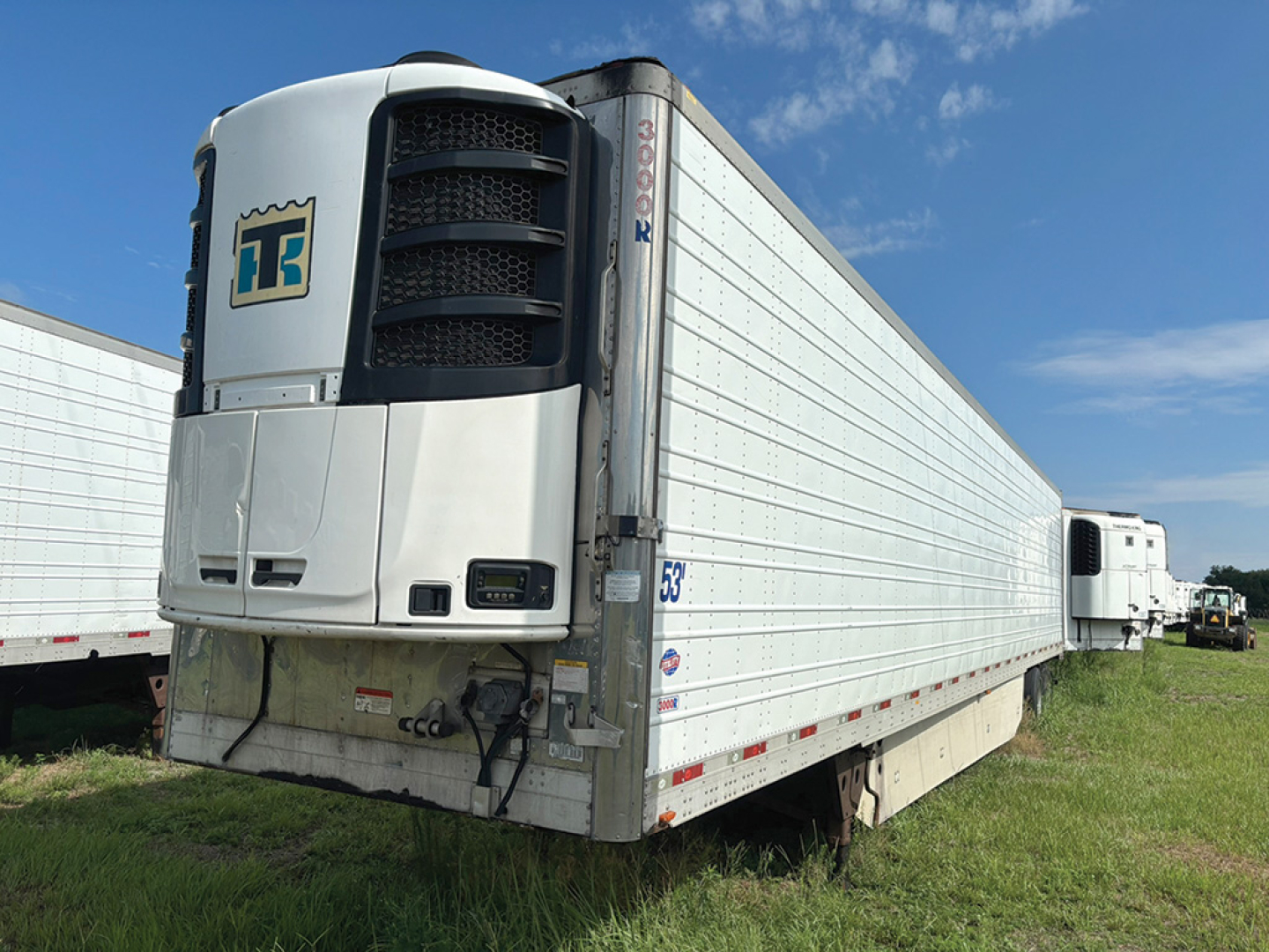 Utility reefer trailer 2016 Utility 3000R with Thermo King unit, side panels, rear roll-up door, and twin-axle connection in a grassy lot.