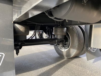 Trailer undercarriage with axle and suspension visible; no explicit text readable.