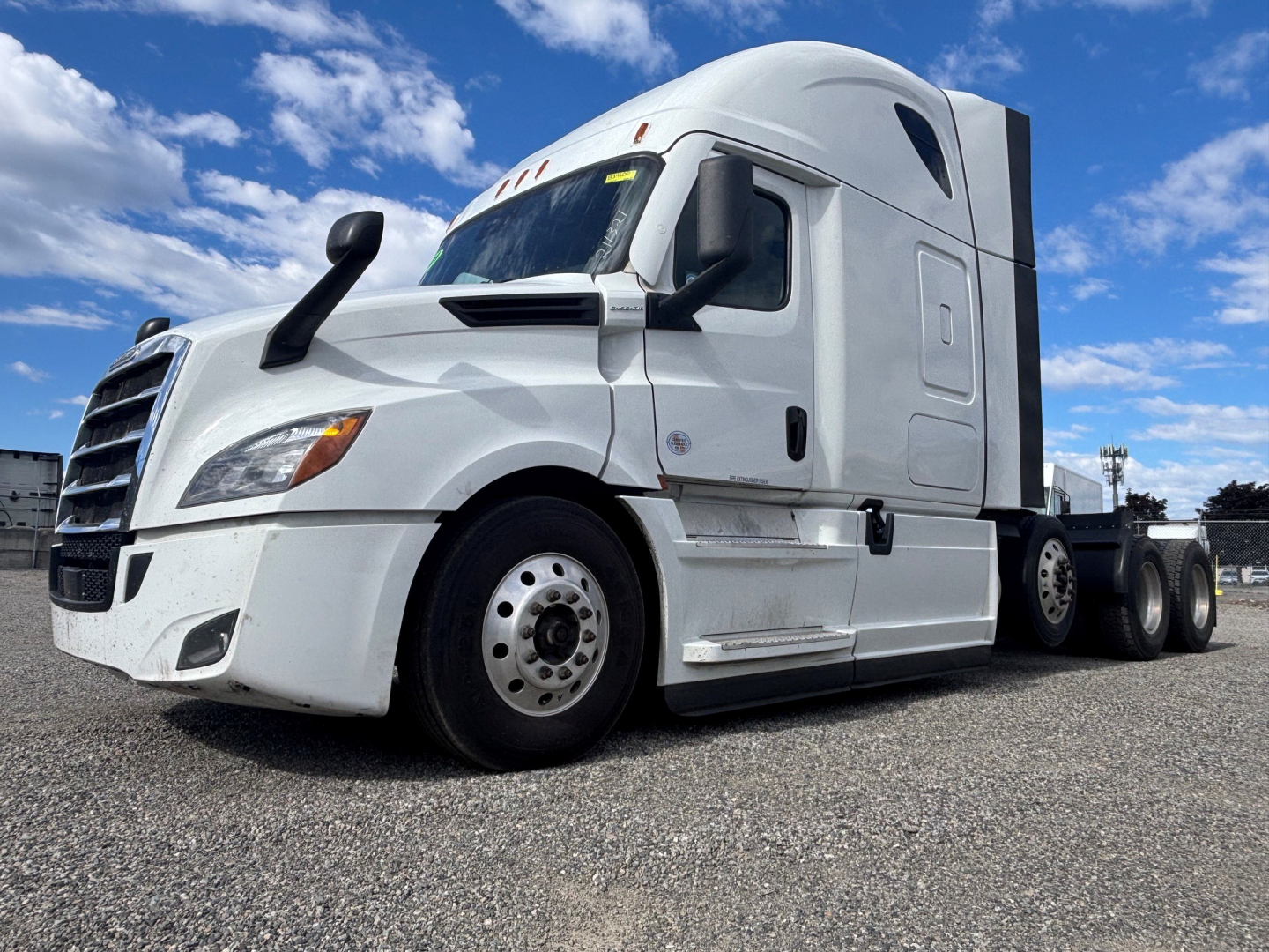 Freightliner tractor-trailer cab shown from front-left, white exterior, aerodynamic sleeper, large side mirrors