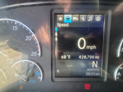 Dashboard in-view showing digital display with Speed 0 mph, outside temperature 68°F, 428,700 miles, gear N, economy mode, and icons along top; left gauge shows tachometer rpm x100, fuel gauge; right gauge shows additional gauges.