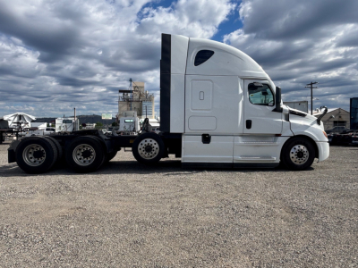 Truck side profile showing a white Freightliner CA-126 sleeper cab tractor with dual rear axles and flatbed chassis, no trailer attached.