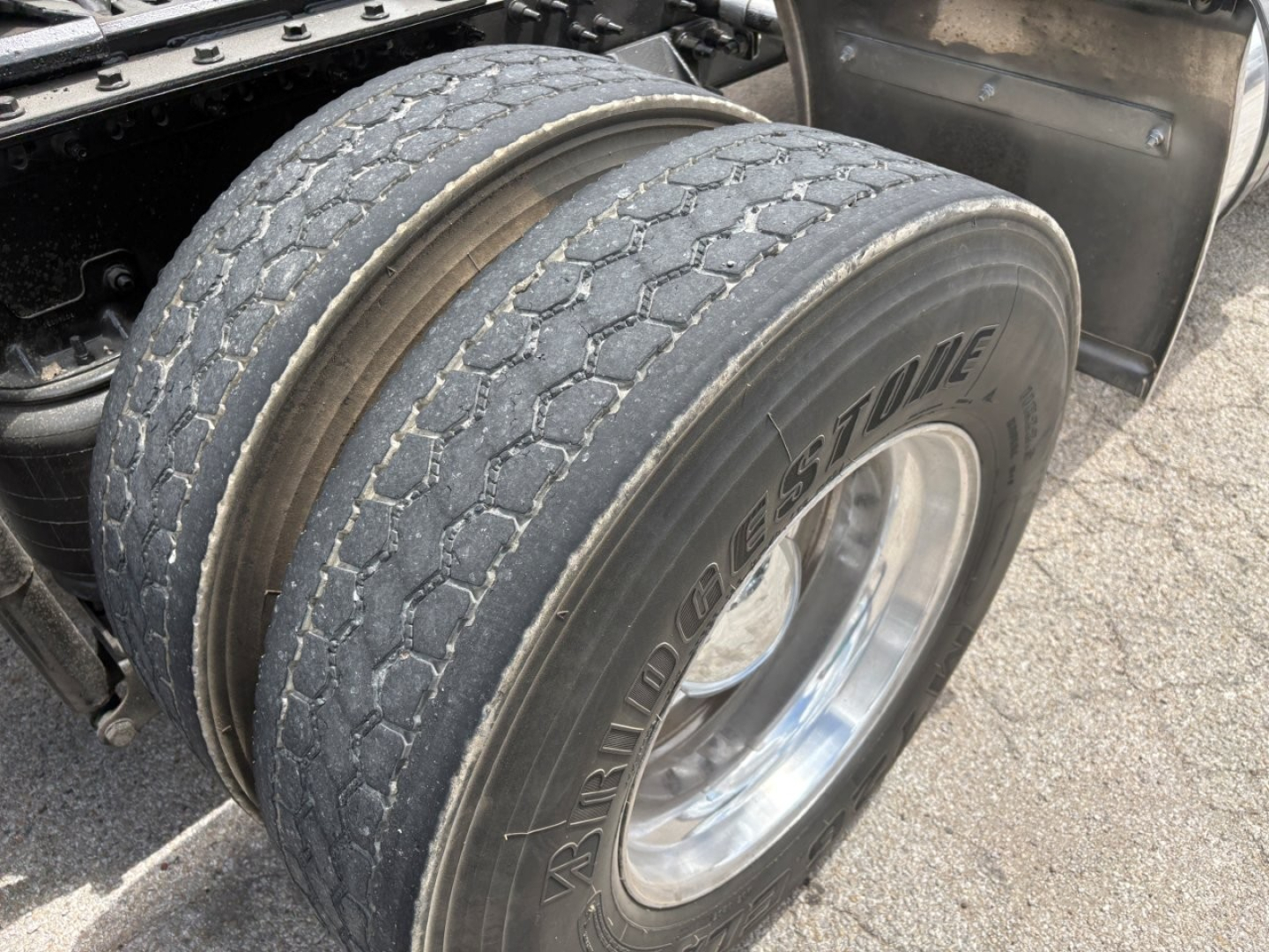 Mack PI64T front dual rear axle tires showing Bridgestone tire tread and chrome wheel with part of the tractor frame.