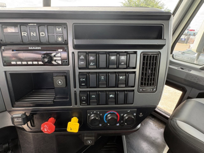 Mack PI64T dashboard view showing control switches and two colored ABC truck power connectors. Includes red and yellow power takeoff knobs and climate controls.