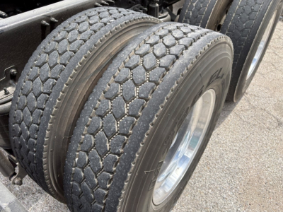 Rear view showing dual rear tires with tread pattern on a Mack PI64T truck.