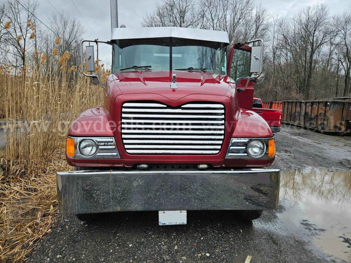 Front view of a red 2003 Mack CV713 Granite truck showing chrome grille, bumper, and headlights.