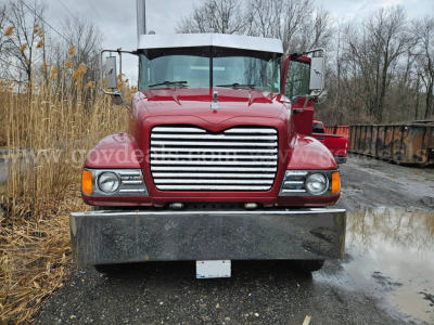 Front view of a red 2003 Mack CV713 Granite truck showing chrome grille, bumper, and headlights.