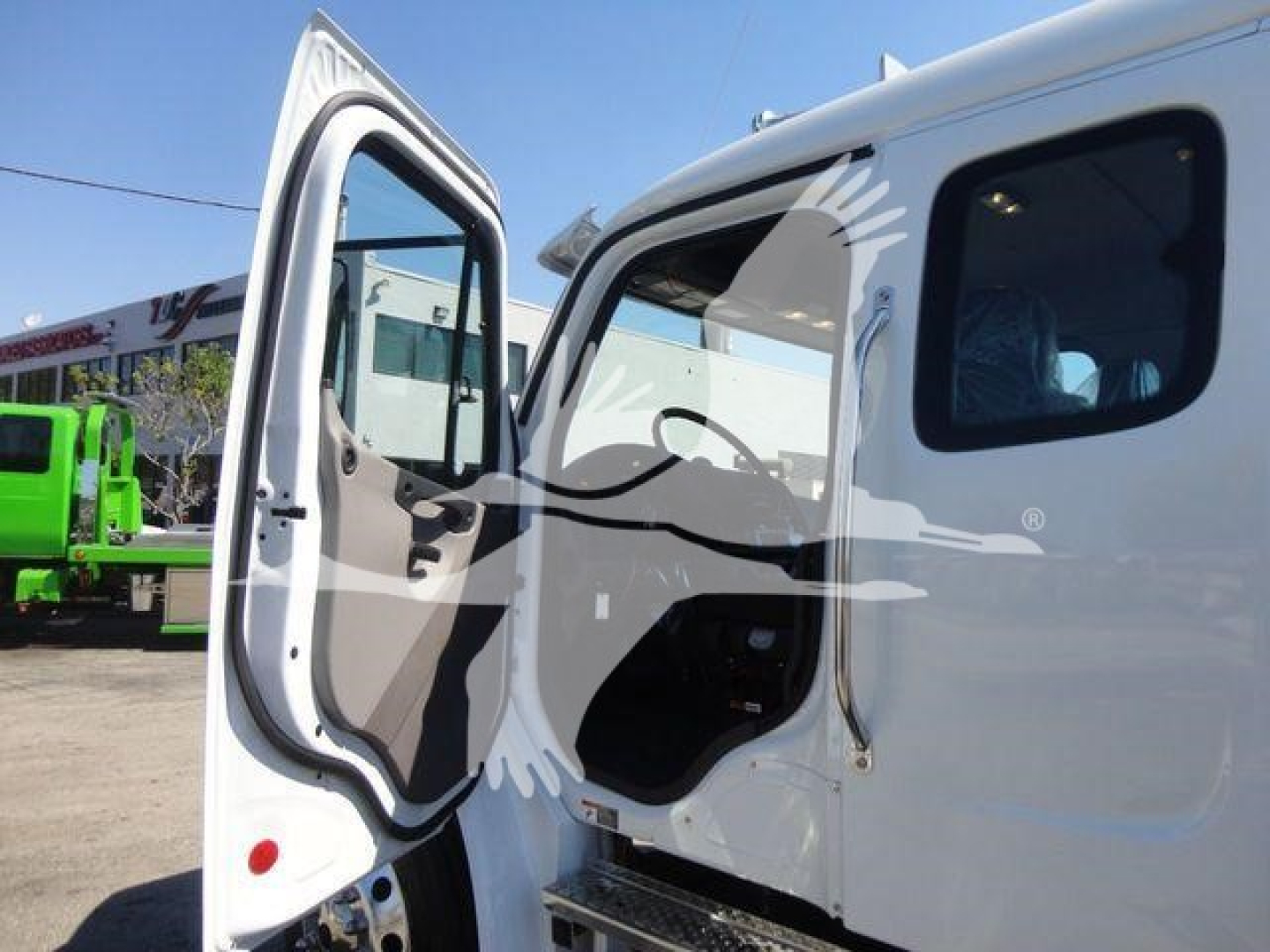Freightliner M2 106 rollback truck cab interior with open door showing steering area and dashboard
