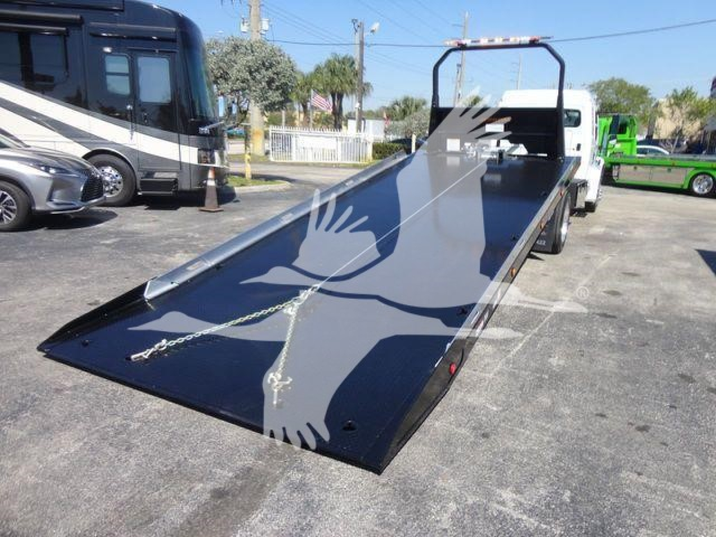 Flatbed rollback truck loading platform extended open deck with ramp and safety chains, Freightliner M2 106 stock image.