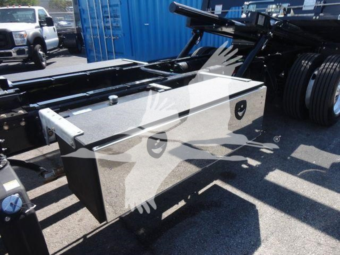Freightliner M2 106 chassis with aluminum toolbox mounted on frame showing storage box and part of roll-back setup.