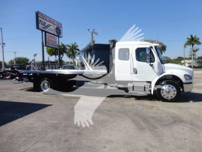 Flatbed tow truck side view showing Freightliner M2 106 chassis with rollback bed