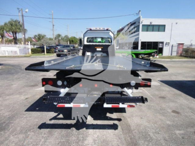 Freightliner M2 106 rollback truck back view showing flatbed and dovetail, chrome bumper, taillights, and towing equipment.