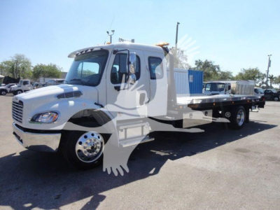 Rolback tow truck chassis with cab showing Freightliner emblem, front grille, half-flatbed with wheel lift; side windows and mirrors visible.