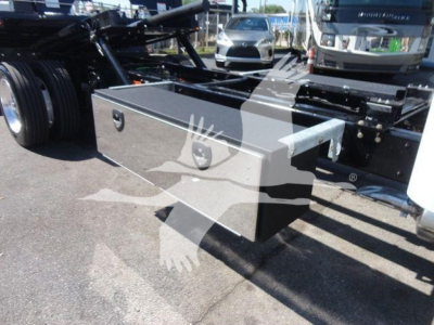 Truck rear with a rectangular silver toolbox mounted under the frame, visible wheel and chassis in background.