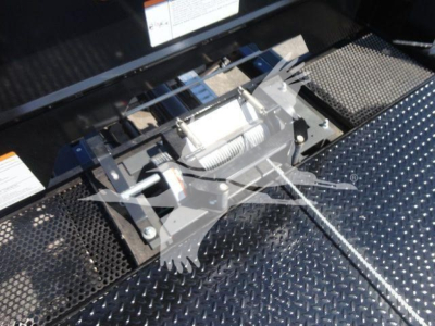 Freightliner M2 106 rollback truck equipment showing winch assembly mounted on diamond plate bed surface.