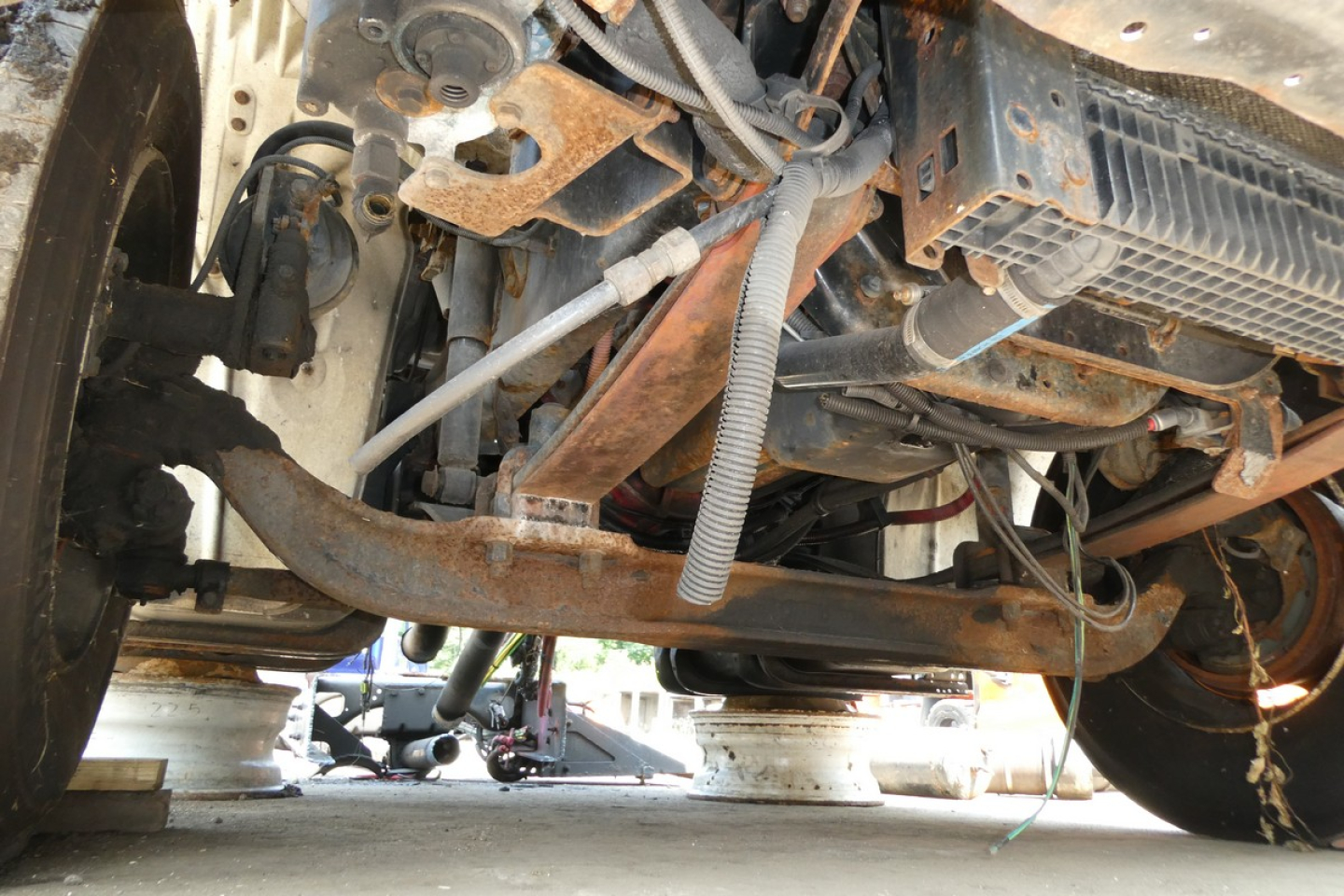 Underbody view of Freightliner M2-106 showing chassis, exhaust pipe, and suspension components.