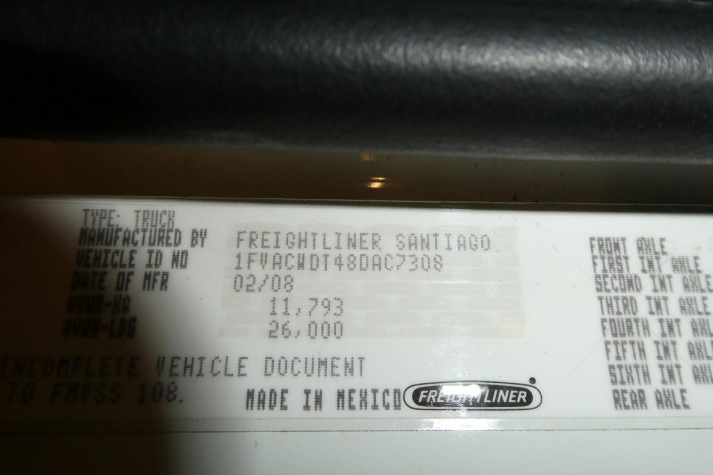 Truck VIN label showing vehicle details: manufactured by Freightliner, MADE IN MEXICO, weight figures, front axle, second axle data, engine and VIN partial text.
