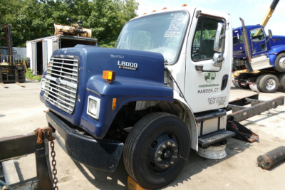 2008 Freightliner M2-106 cab over engine hood with L8000 diesel badge and front grille visible in a yard.