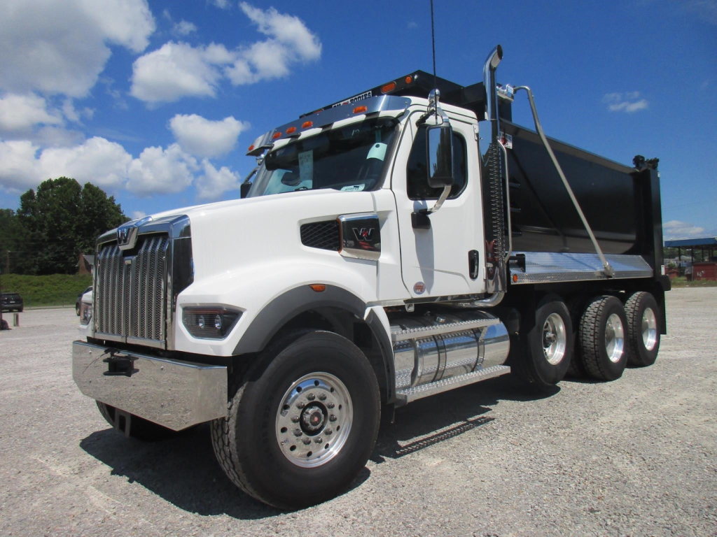 Western Star 49X dump truck side view showing white cab, black dump bed, chrome front bumper, dual rear axles, and large side mirrors.