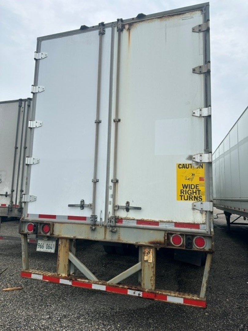 Back view of a 2009 Great Dane dry van trailer showing double doors with hinges, rear bumper, taillights, and caution sticker on door.
