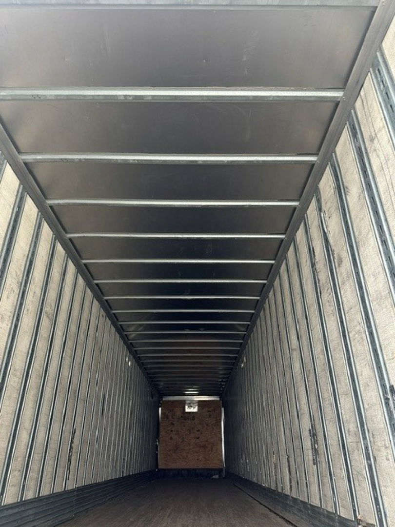 Inside view of a 2009 Great Dane dry van trailer, metal ribbed walls and ceiling with a wooden floor section visible at far end.