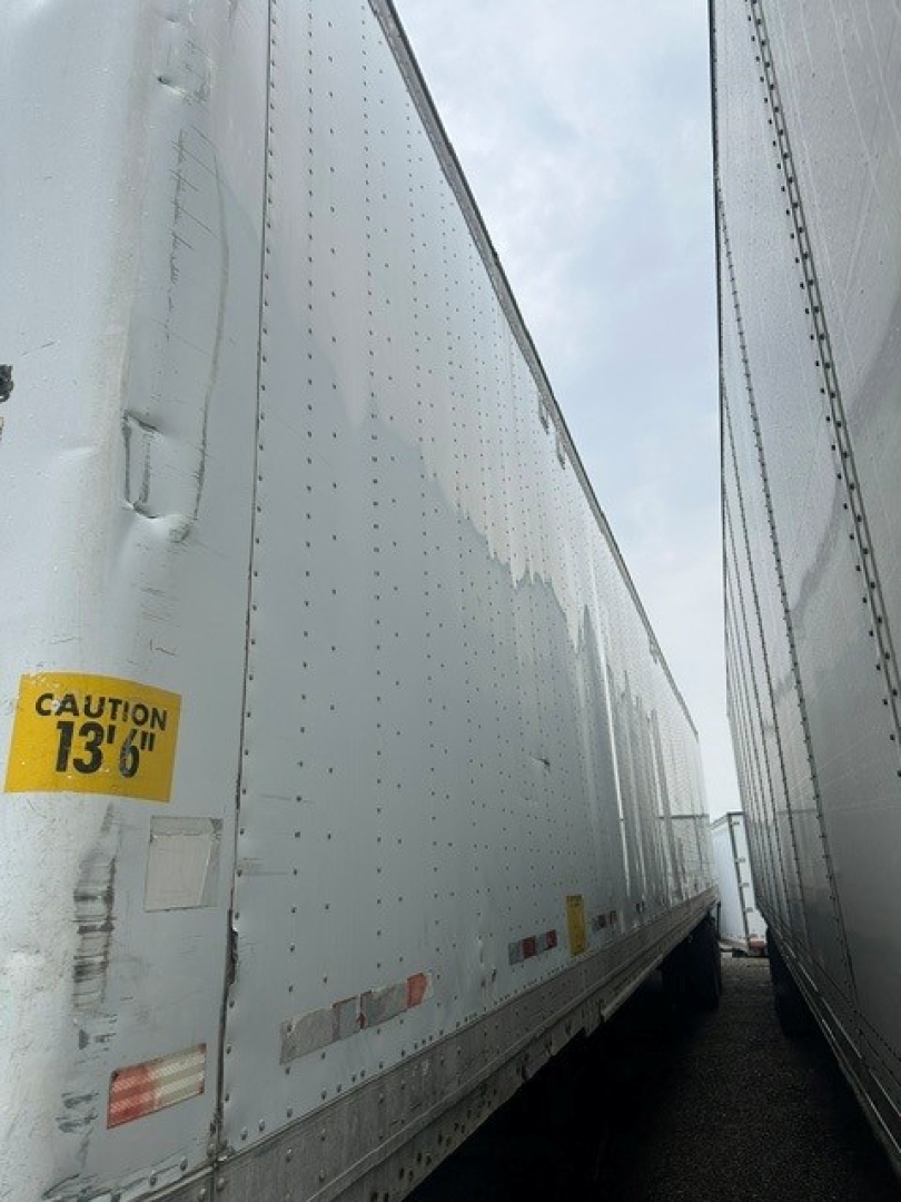 Dual gray Great Dane dry van trailers showing riveted aluminum sides and a caution sticker reading 13'6" near the left edge.