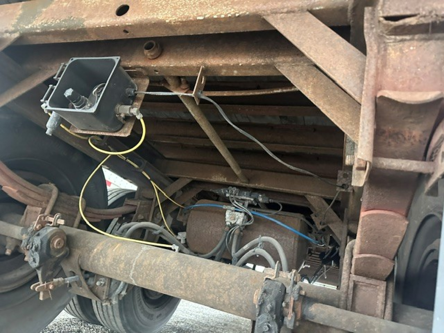 Suspension and undercarriage of a 2009 Great Dane dry van trailer showing axles, leaf springs, brake components, visible wiring, and rusted frame members.