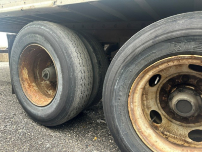 Dual rear tires on a used 2009 Great Dane dry van trailer showing worn rims and exposed wheel hubs.