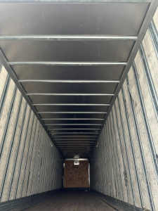 Inside view of a 2009 Great Dane dry van trailer, metal ribbed walls and ceiling with a wooden floor section visible at far end.