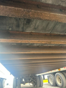 Trailer underside view showing metal beams and wheel area of a Great Dane dry van trailer.