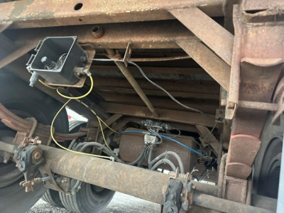 Suspension and undercarriage of a 2009 Great Dane dry van trailer showing axles, leaf springs, brake components, visible wiring, and rusted frame members.