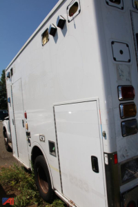 Ambulance rear side showing utility compartments and tail lights on a 2016 Ford F-350 Super Duty ambulance.