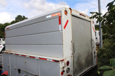 GMC Sierra 3500 utility truck body rear view showing roll-up tailgate and storage compartments.