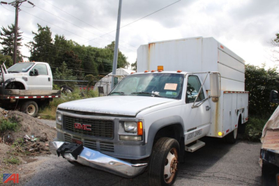 Utility truck: 2002 GMC Sierra 3500 with a utility box on a service bed, front bumper and grille visible.
