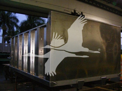Dump truck trailer side showing a large white bird graphic on a metallic surface.