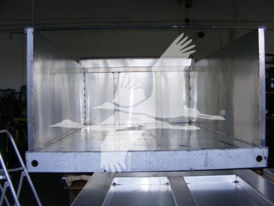 Dump truck bed showing empty aluminum dump body with open tailgate, inside reflective sides, 12 ft length, factory welds visible.