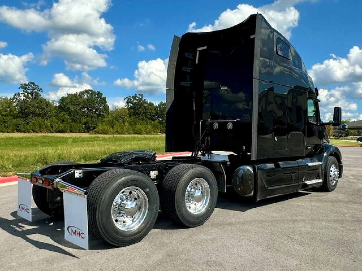 Peterbilt 579 conventional sleeper truck rear 6x4 chassis with fifth wheel exposed and glossy black cab.