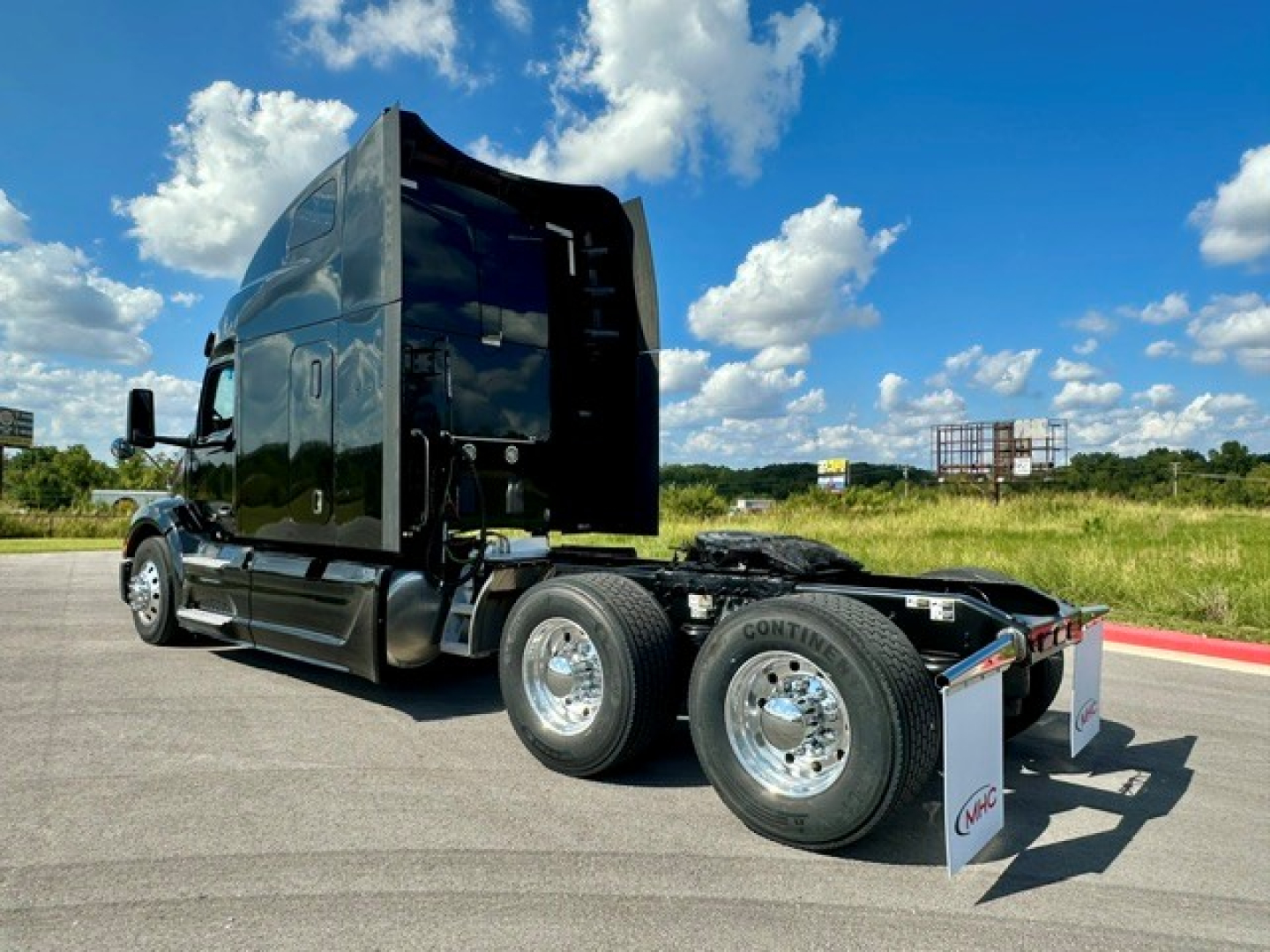 Peterbilt 579 tractor profile with sleeper cab, black exterior, dual rear axles, chrome wheels, and open hood area.