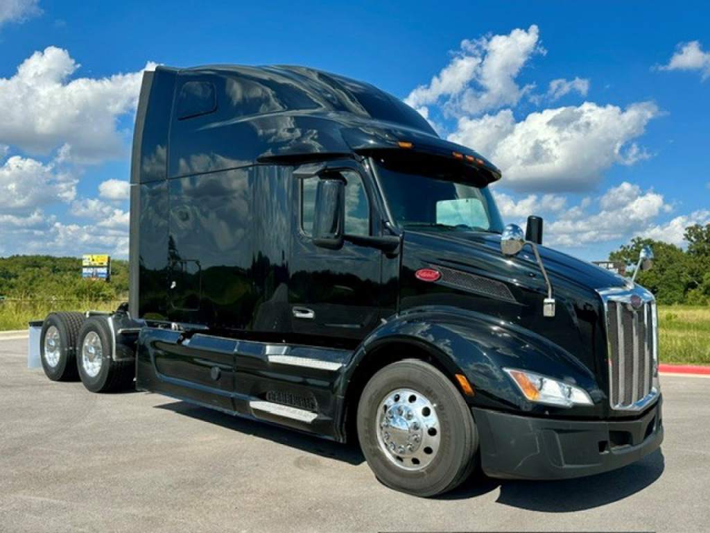 Peterbilt 579 truck shown in black, side view with sleeper cab, chrome wheels, and dual rear axles.