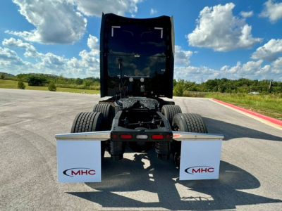 Peterbilt 579 tractor chassis back view showing mud flaps with MHC logo, chassis rails, and fifth wheel area.
