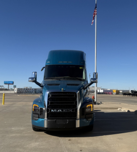 Front view of a blue 2026 Mack PR64T76H conventional sleeper truck showing bold grille and headlights.