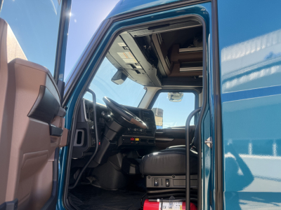 Cab interior of a 2026 Mack PR64T76H sleeper truck showing modern dashboard and driver seat from open door view.