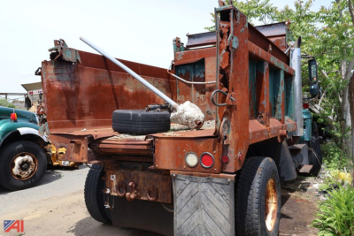 Dump truck bed and rear view of a 2005 International WorkStar 7400 dump truck showing rusted metal bed, dual rear tires, and a spare tire in the bed.