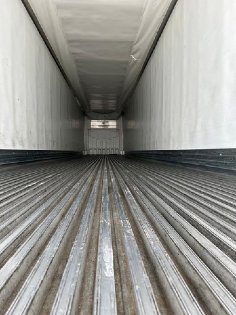 Trailer interior view of a 2021 utility reefer cargo area with ribbed floor and white walls.
