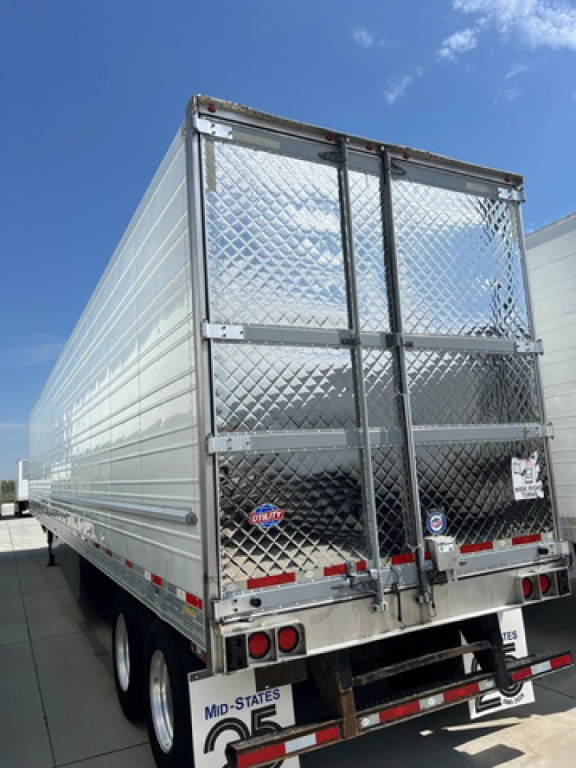 Rear view of a 2021 Utility reefer trailer with diamond plate doors and dual axles.