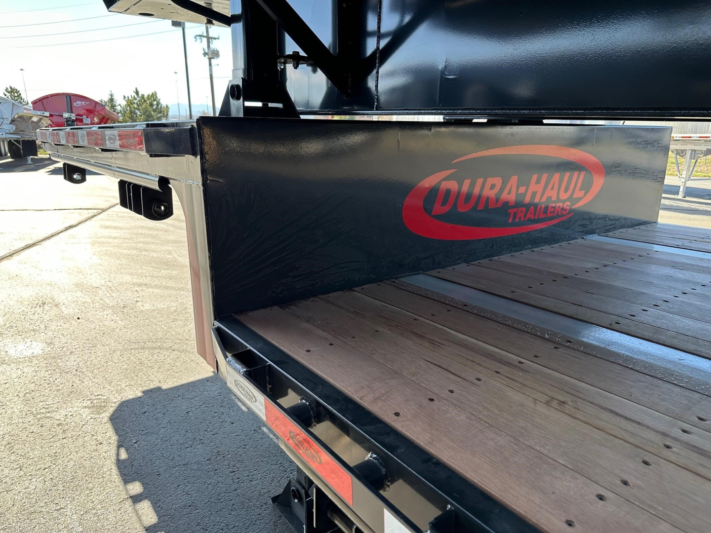 Dura-Haul trailer showing a closed tandem steel drop deck with wood deck planks and DURA-HAUL logo on metal side panel.