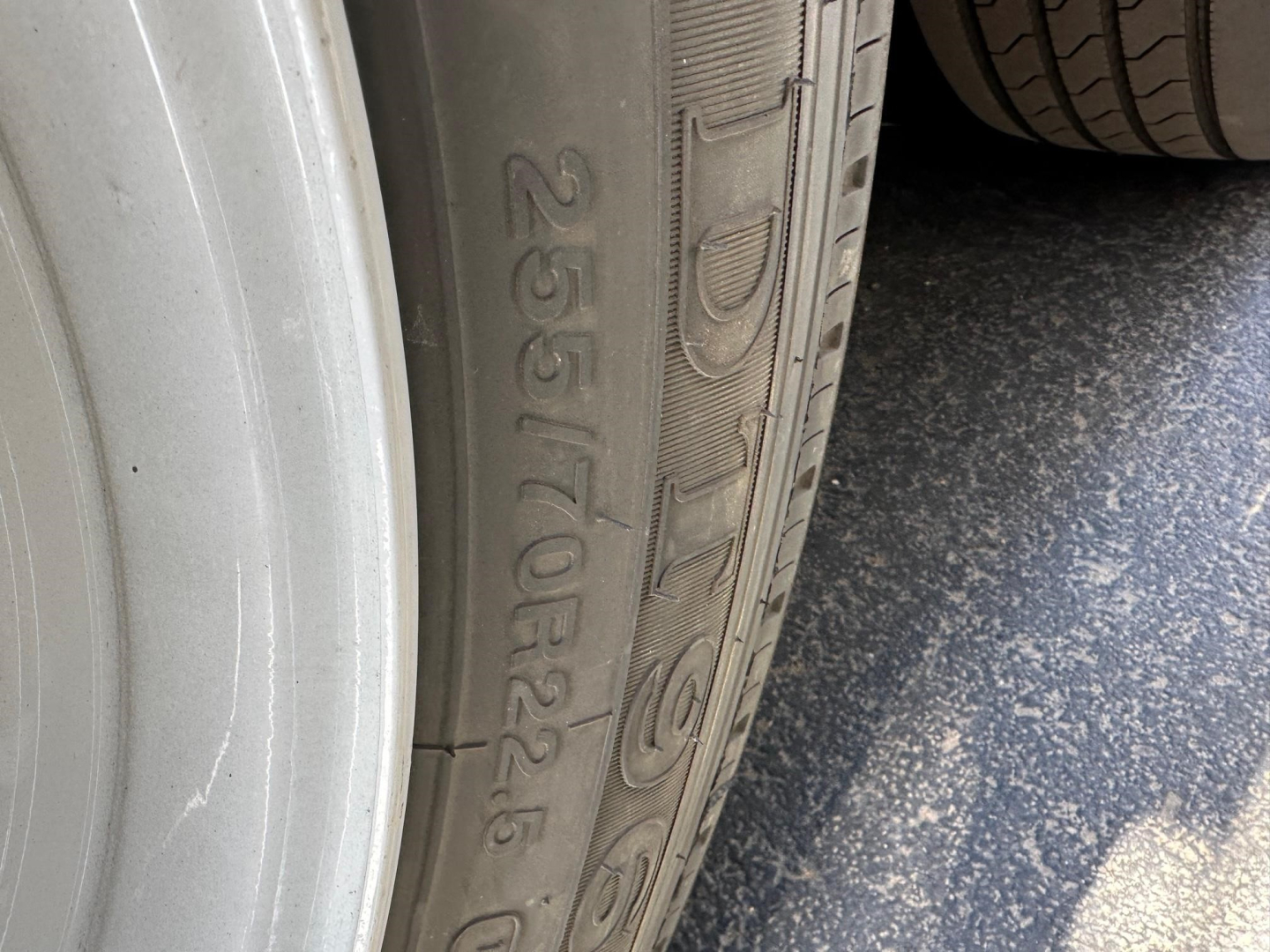 Tire sidewall with embossed markings 265/70R22.5 and other alphanumeric characters.