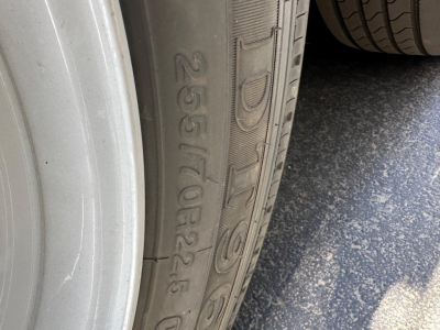 Tire sidewall with embossed markings 265/70R22.5 and other alphanumeric characters.
